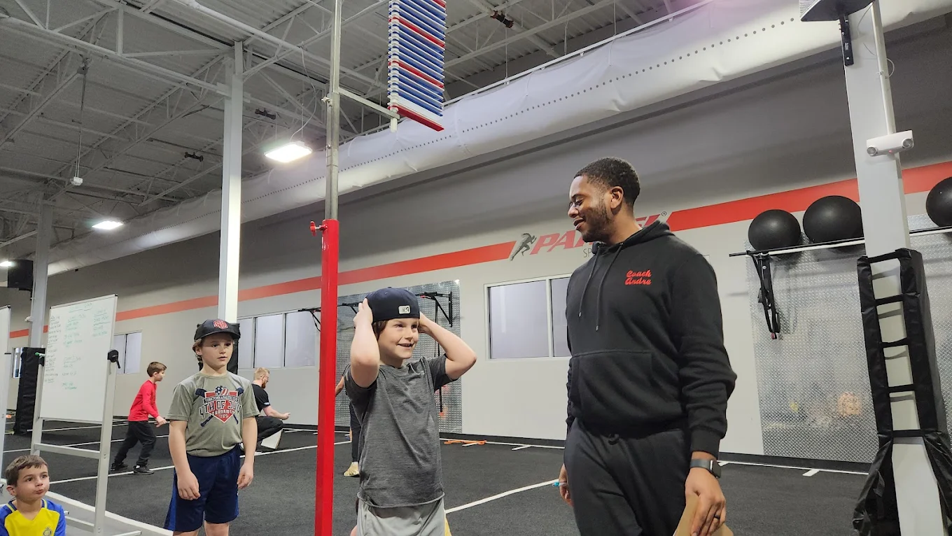Coach smiling with a young athlete at Parisi